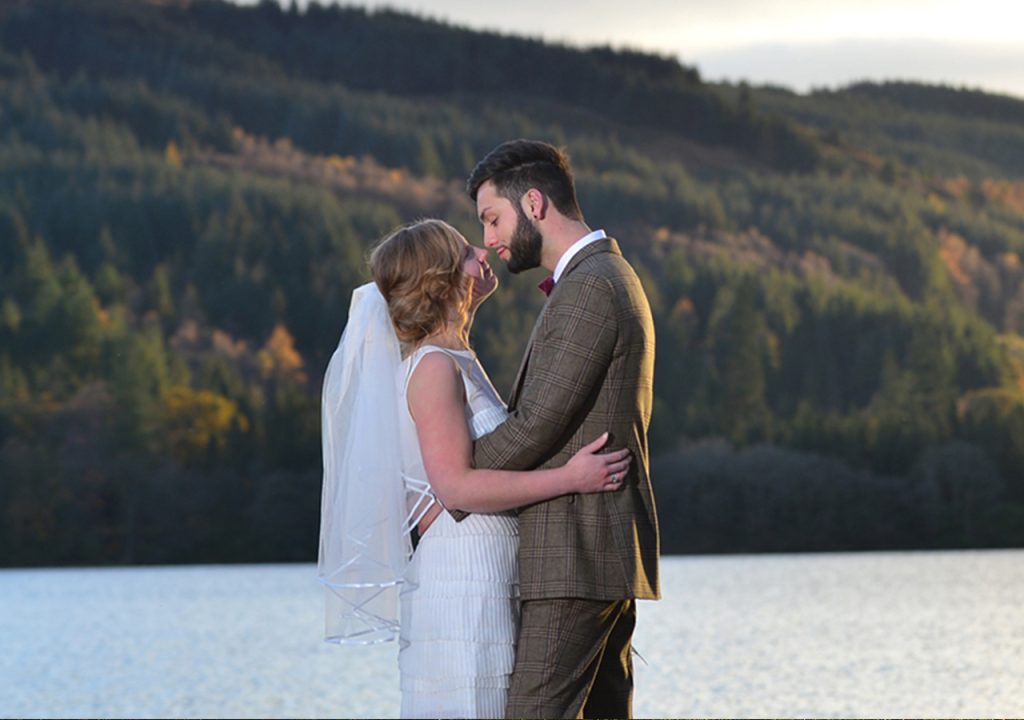 A bride and groom by Loch Venachar in an Autumn wedding