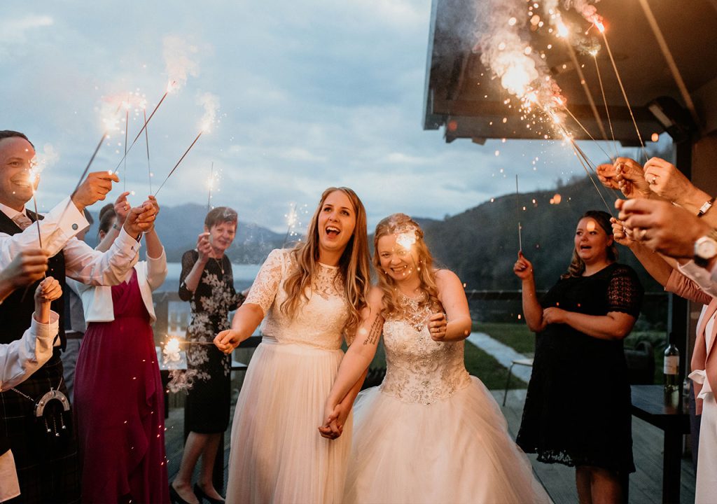 Brides and guests with sparklers at Loch Venechar