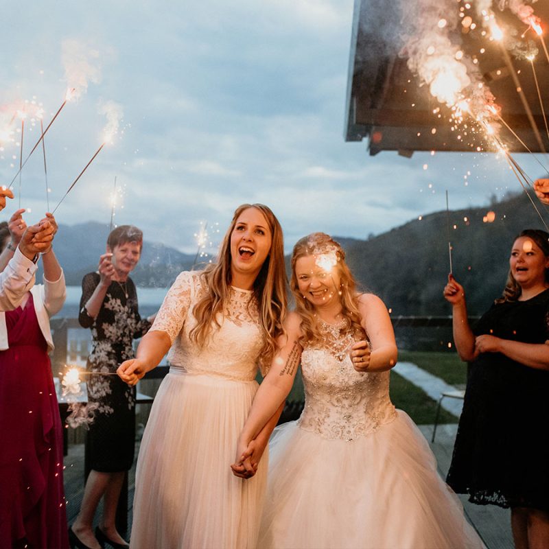 Brides and guests with sparklers at Loch Venechar