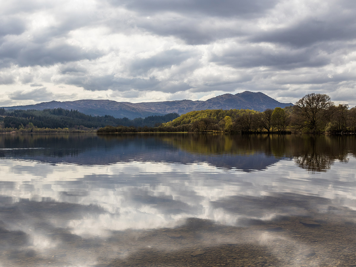 A view of Loch Venachar with the hills reflecting on the glassy water