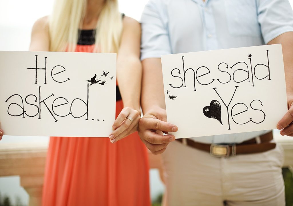 Engaged couple with signs