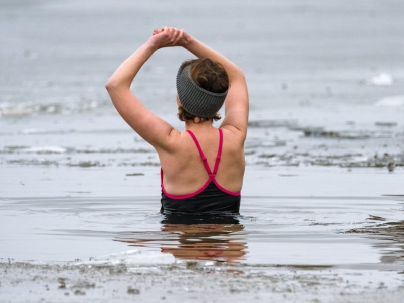 A lady wild swimmng at loch venachar in winter