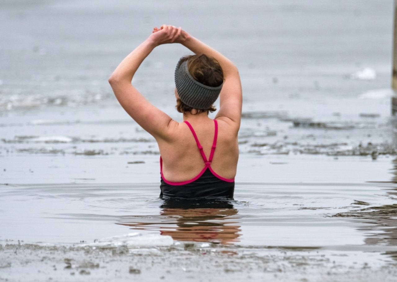 A lady wild swimmng at loch venachar in winter