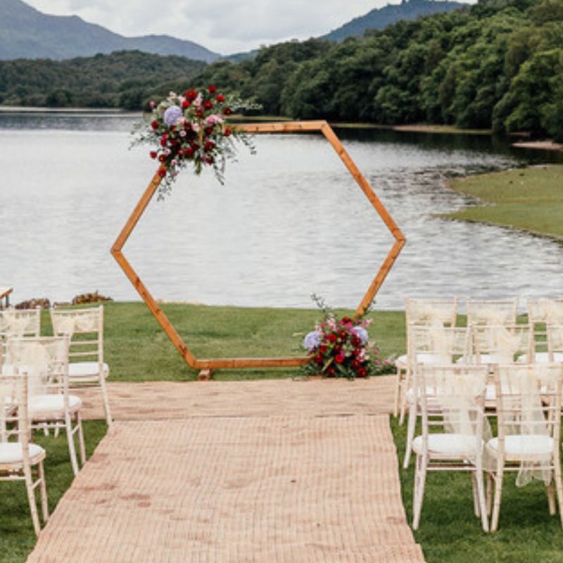 Wedding ceremony set up with arch beside a loch.