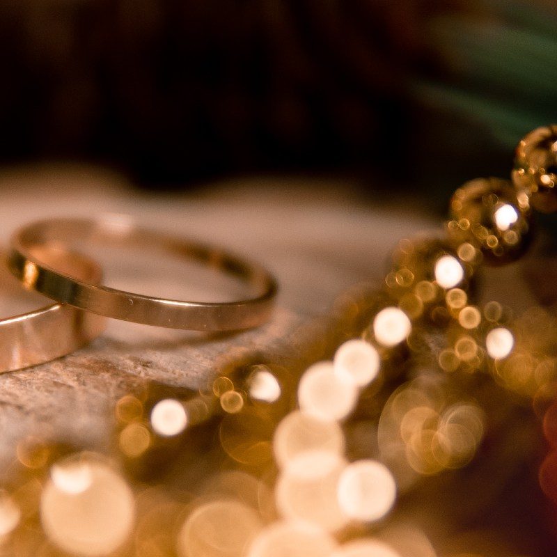 yellow rings lie on a piece of wood. around there are branches of a Christmas tree