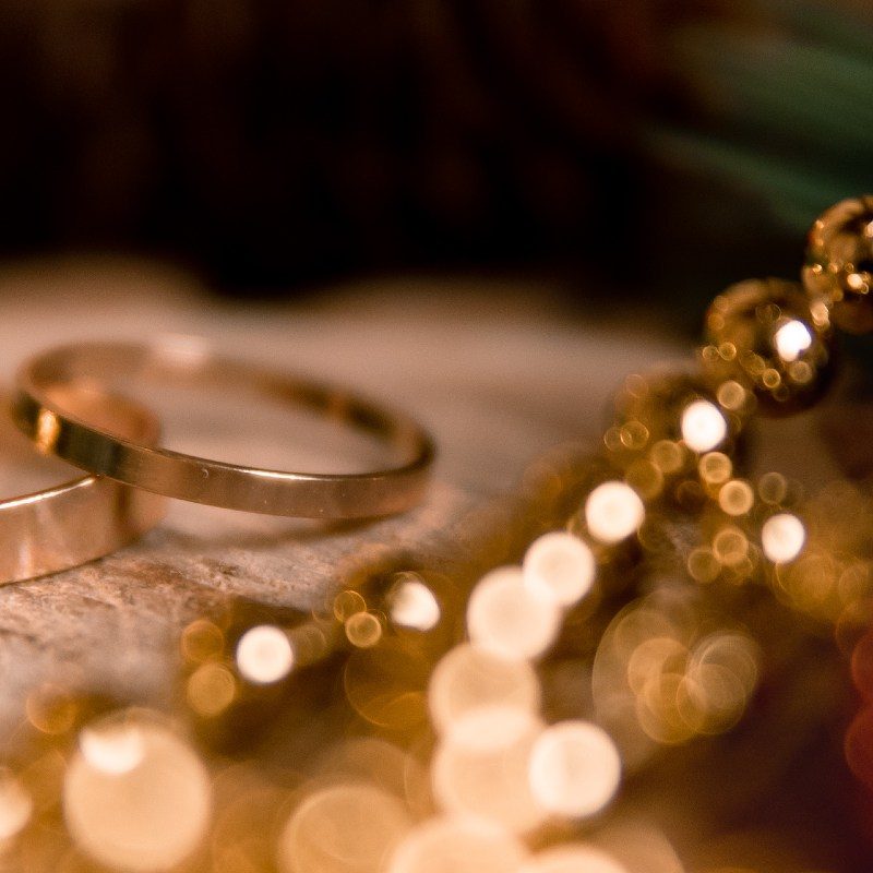 yellow rings lie on a piece of wood. around there are branches of a Christmas tree