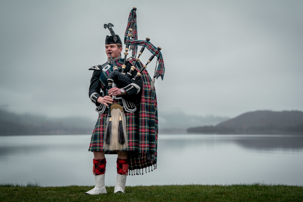 A piper on the shores of Loch Venachar in winter