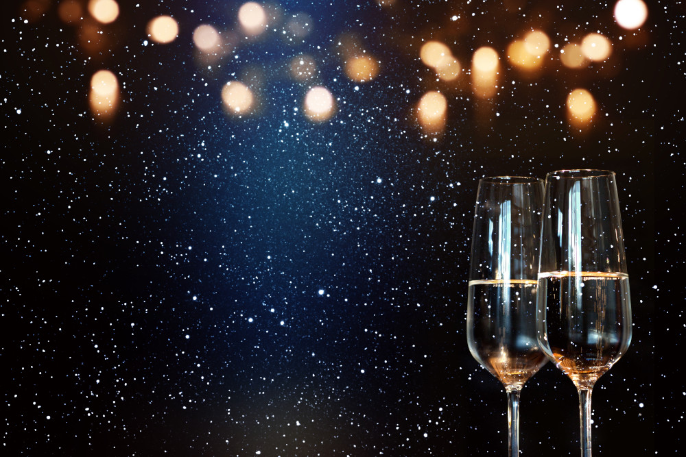 Twi glasses of champagne against a starry sky