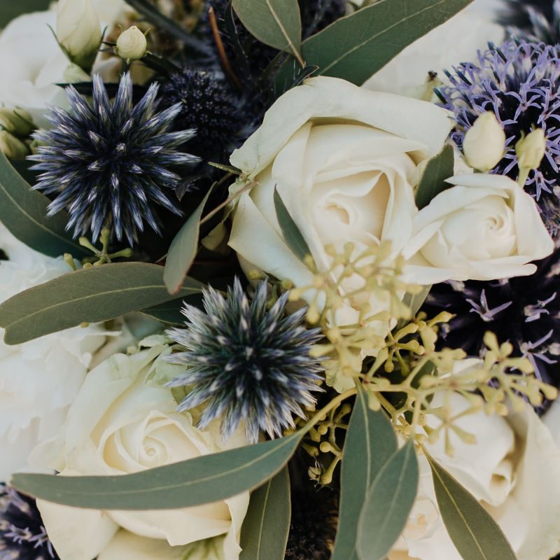 A wedding bouquet with roses and thistles